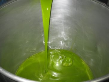 Aceite de oliva recién extraído cayendo en un depósito